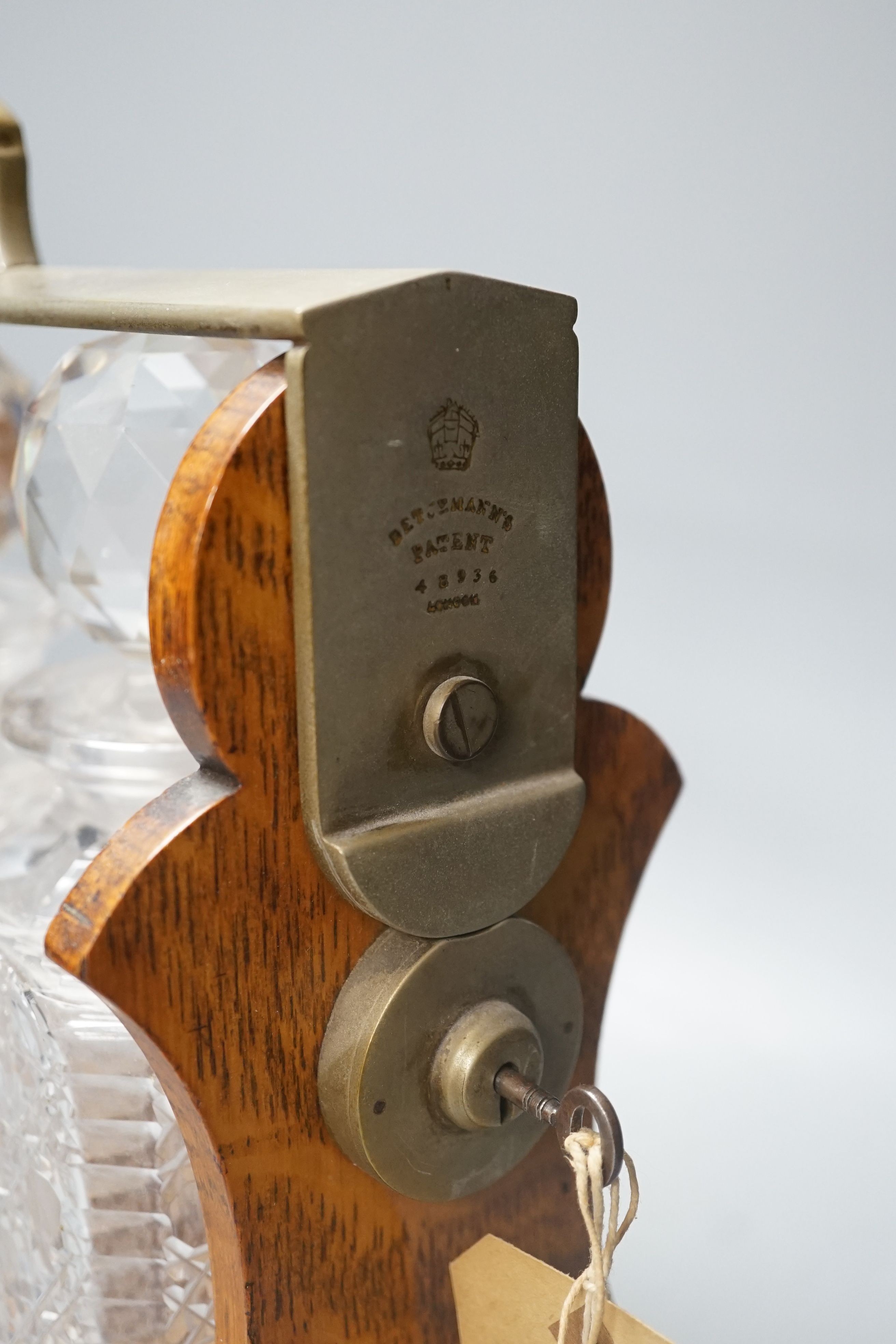 Early 20th century Betjemann's Patent oak 3 bottle tantalus, 32 cms high.